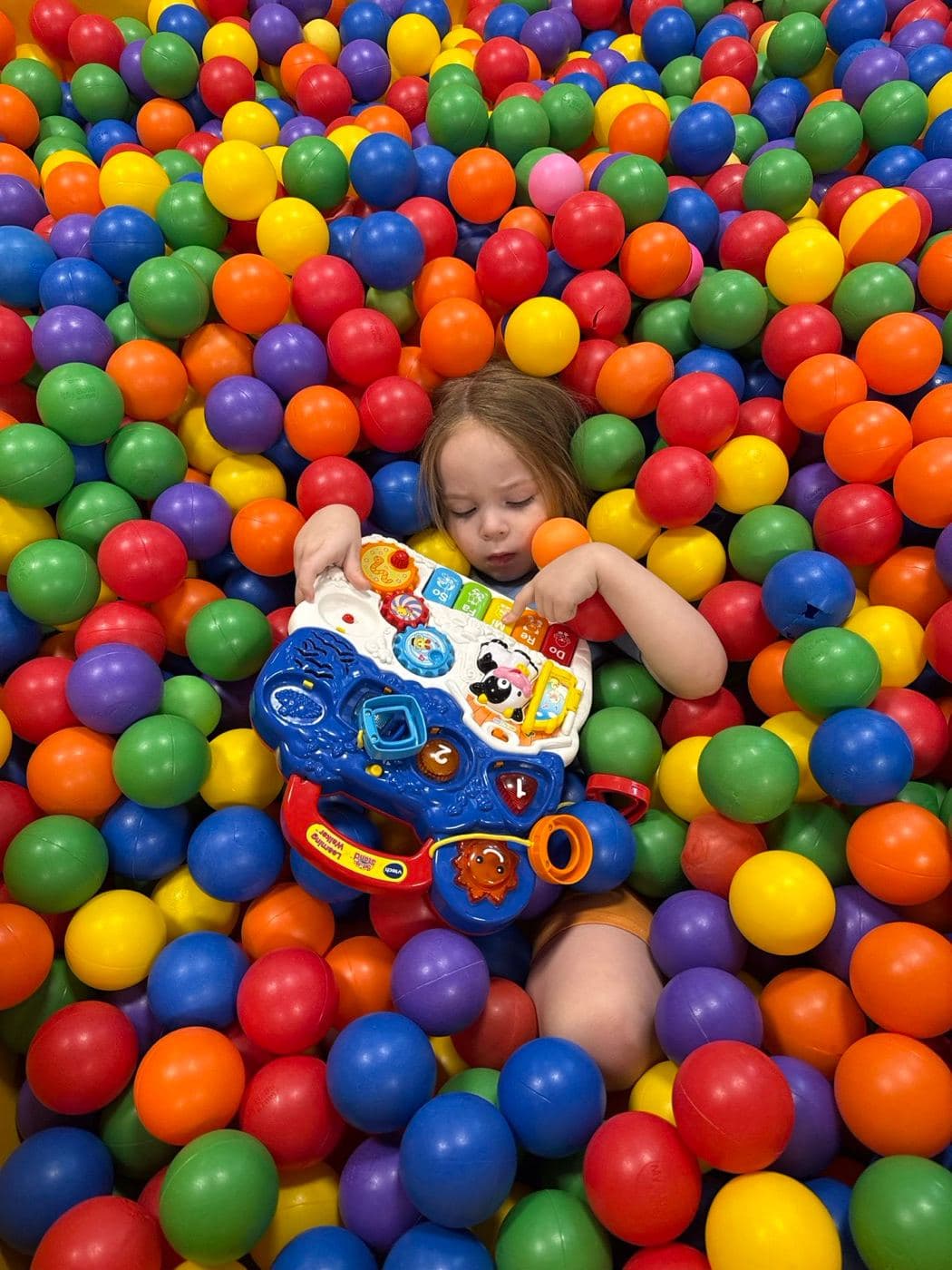 A child playing in the ball pit
