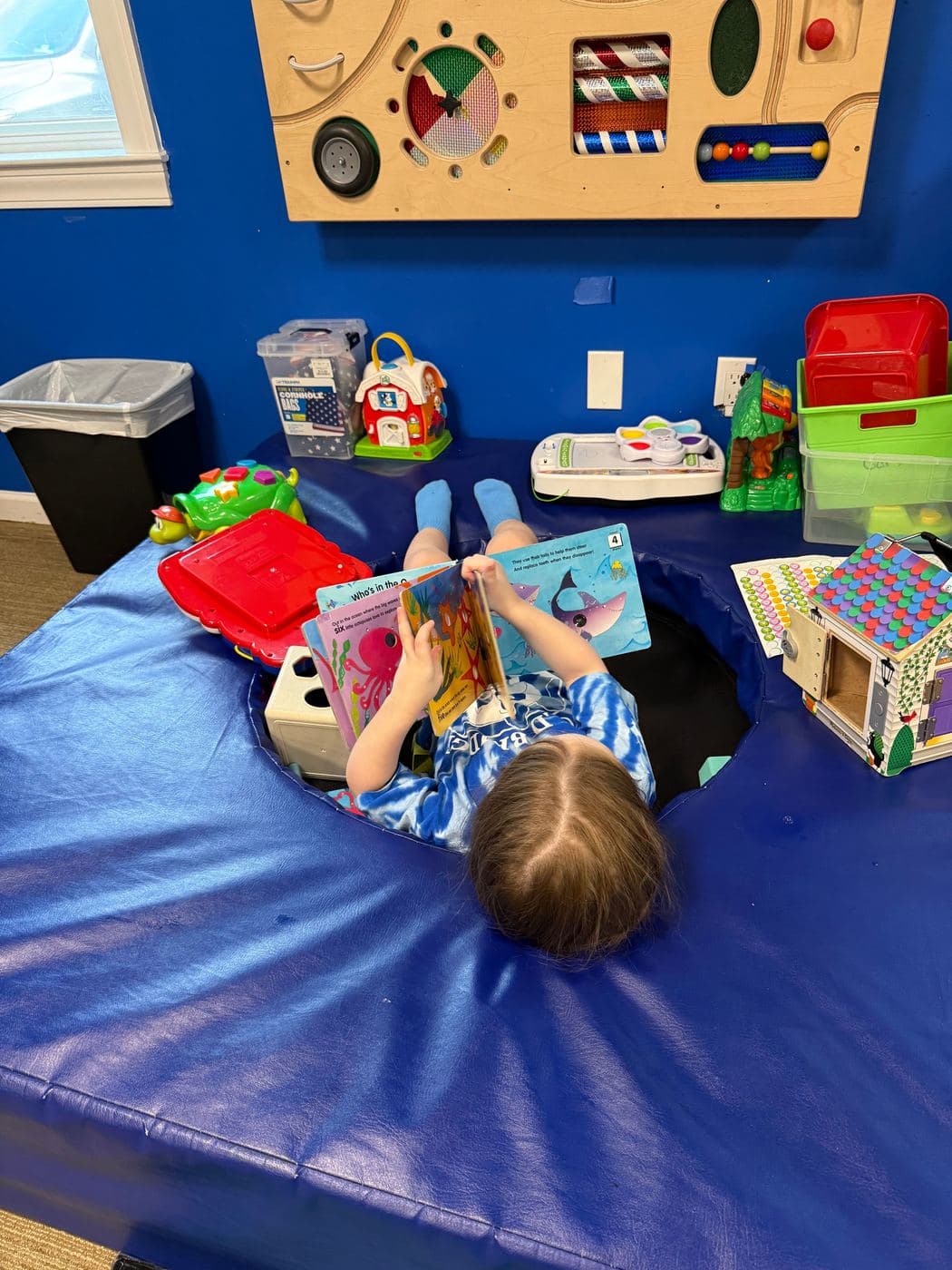 A child reading picture books in a cozy nook