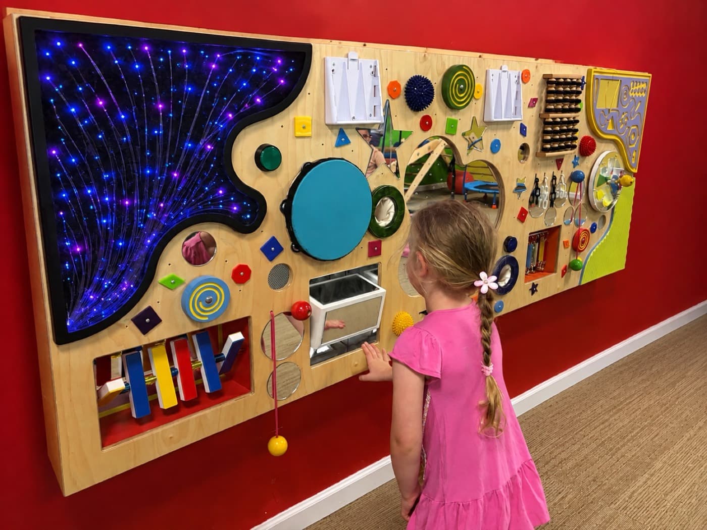 A child exploring the interactive sensory activity wall